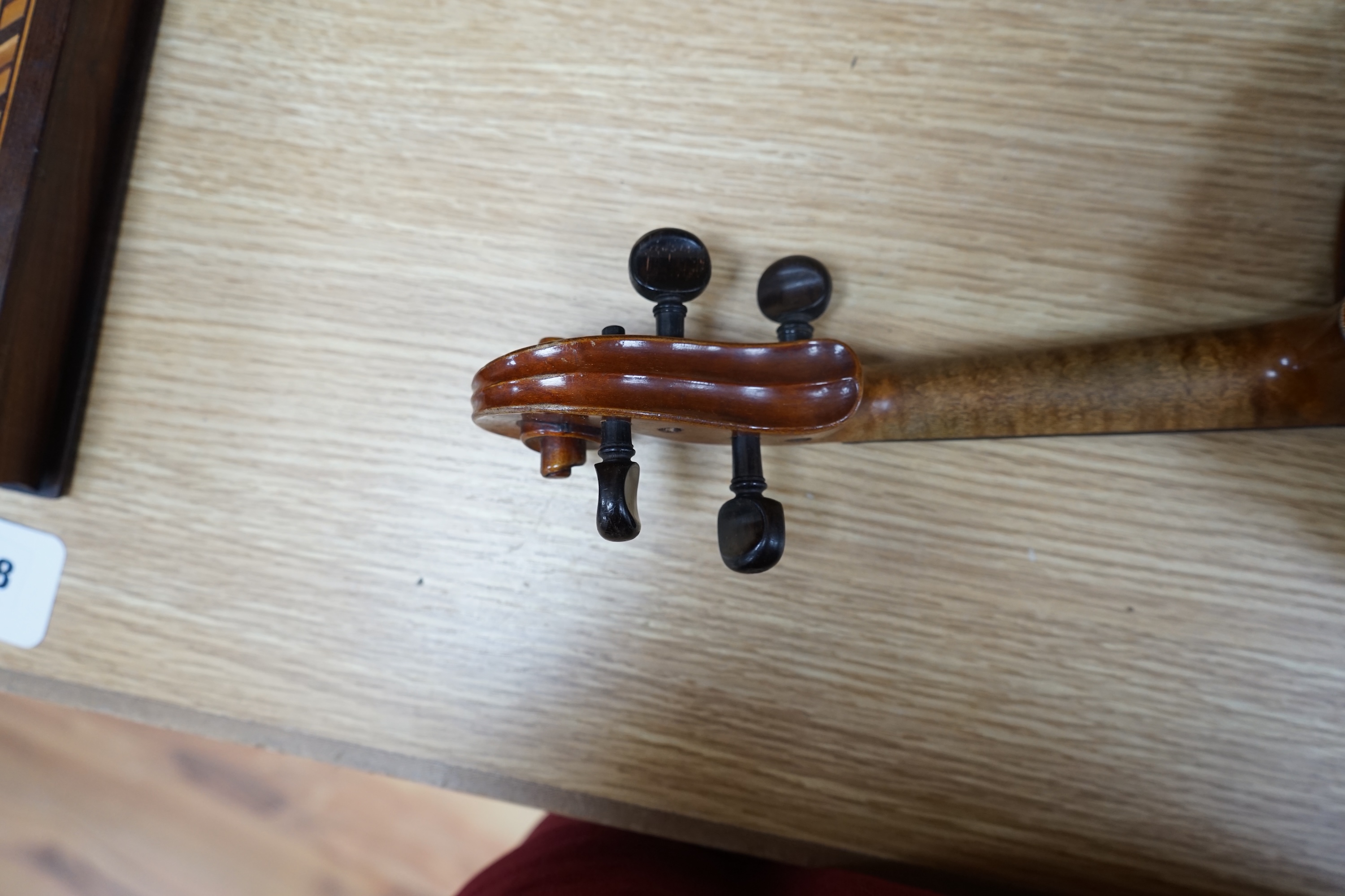 A cased early 20th century violin with bow, no label, back measures 35.5cm. Condition - fair to good